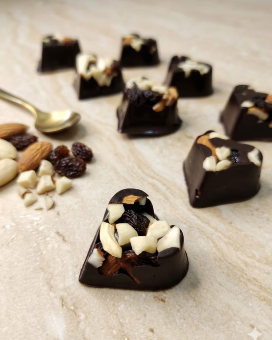 Heart-shaped chocolate truffle with nuts and raisins on a light surface